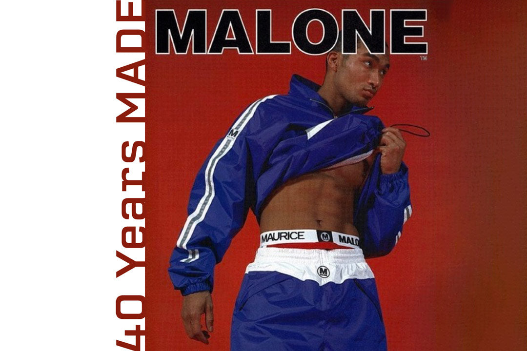 A vintage 1995 Maurice Malone streetwear advertisement features and white 90s track suit, adorned with reflective silver stripes and underwear with logo-emblazoned waistband