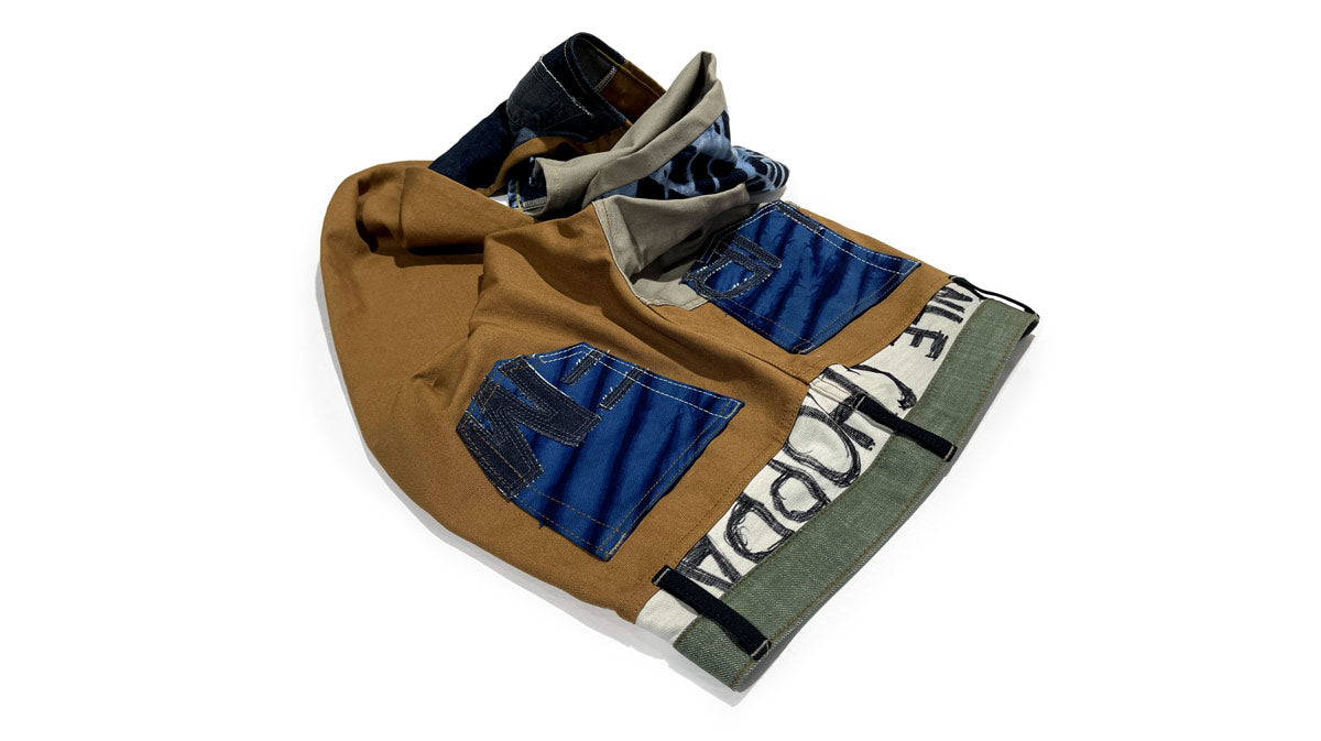 Maurice Malone's handcrafted NLE Choppa jeans, uniquely fashioned from denim scraps. Showcasing patchwork paneling, the rapper's name is artfully inscribed on the yoke and intricately stitched into the seams.