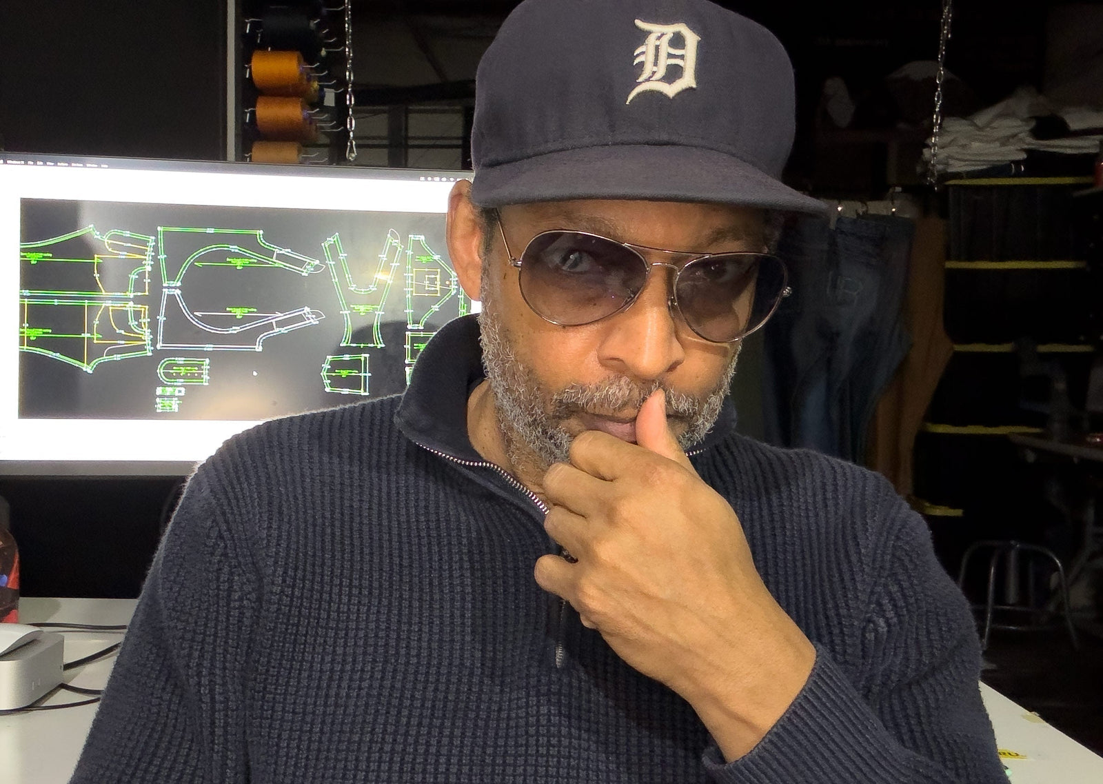 Denim designer Maurice Malone in Brooklyn studio with digital jean pattern on screen behind him, promoting Denim Talk online denim meetup, with Making A Brand, and Williamsburg Garment Company.