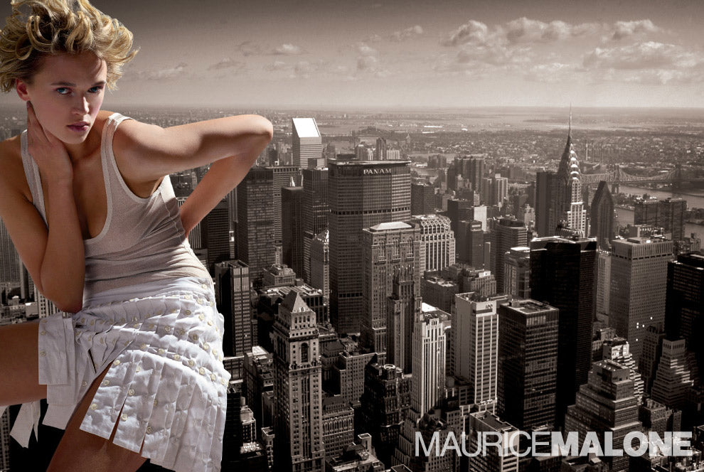 A 2004 women's advertisement from hip-hop's first high-end fashion designer, Maurice Malone, features a giant lady in an all-buttoned skirt sitting on top of a building in New York City.
