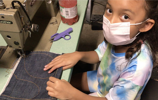 Rae Malone, the world's youngest denim designer sewing fabric