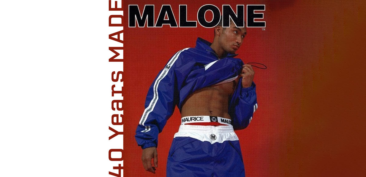 A vintage 1995 Maurice Malone streetwear advertisement features and white 90s track suit, adorned with reflective silver stripes and underwear with logo-emblazoned waistband