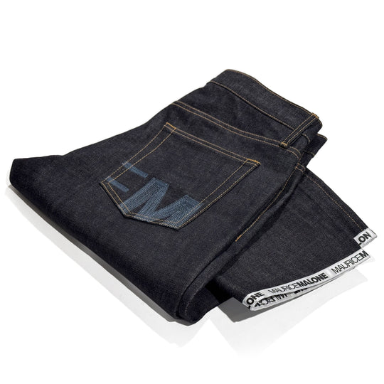 Maurice Malone logo cuff jeans, crafted from 15-oz Japanese Selvedge raw denim, folded to showcase the hand-sewn rear pocket logos and the signature white logo hem.