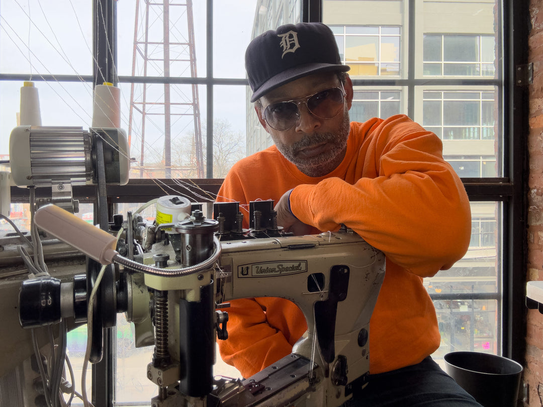 Maurice Malone sits behind his Union Special 35800  industrial sewing machine teaching denim workshop and jeans making school in Brooklyn, New York.