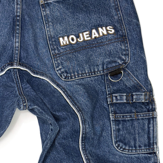 Close-up view of the back carpenter pocket of vintage 1999 Mojeans Blade Runner jeans by Maurice Malone, featuring a reflective Mojeans logo, piping, and D-ring details.