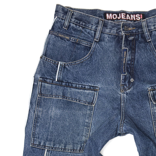 Close-up of 1999 Mojeans Blade Runner jeans front featuring cargo thigh pocket, reflective piping, branded fly tab, and vintage 90s hip hop denim construction.