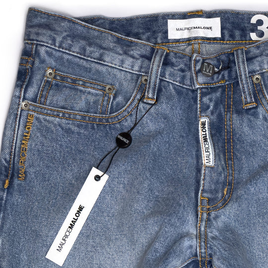 Waistband and fly detail of Maurice Malone 2026 Logo Cuff jeans in stonewashed denim, showing branding and stitch detail.